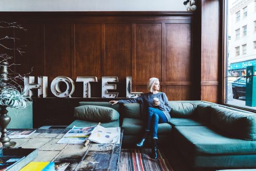 femme assise dans le salon d'un hôtel tenant une tasse à la main